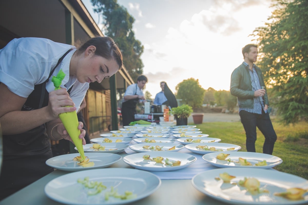 Chef decorating plates outdoors